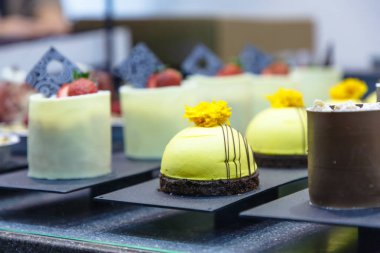 Birçok farklı küçük kek şeker dükkanı camda vardır.