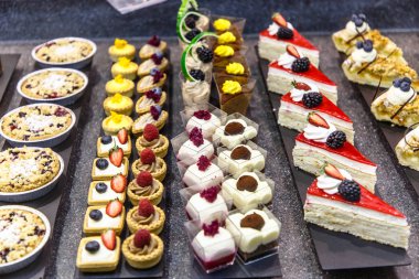 Birçok farklı küçük kek şeker dükkanı camda vardır.