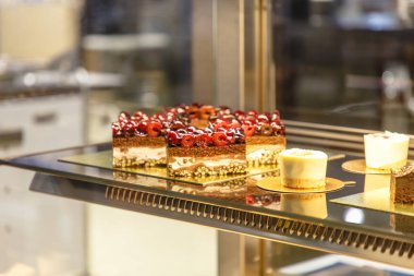 Bir pastane tezgahın üzerine birçok farklı kek vardır.