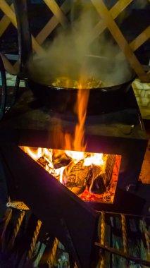 Kazan içinde açık bir yangın geceleri yemek.