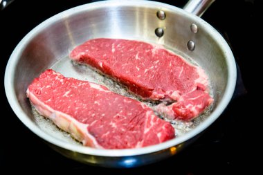 Sığır eti biftek bir çelik tencerede kızartılır