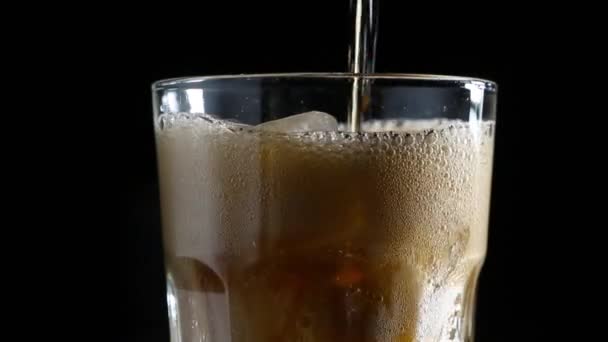 泡とコーラは氷のグラスに注いだ 黒の背景 — ストック動画