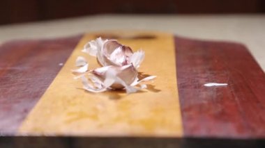 Şef sarımsak kabuğu üzerinden bir bıçak ile temizler..