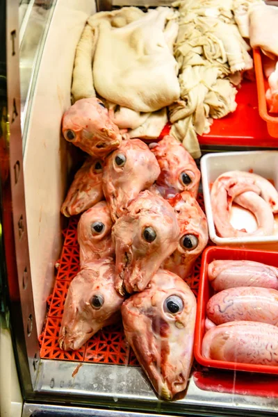 Raw Heads of lambs and other offal on the counter in the butcher shop