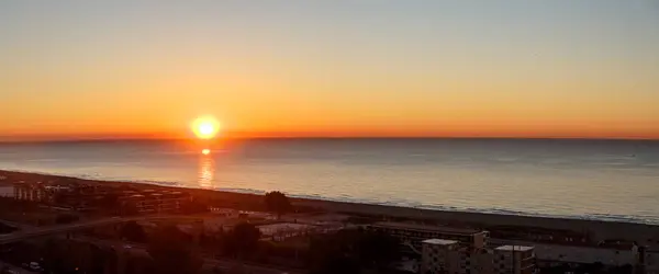 The sun rises (sunrise) over the sea, early morning