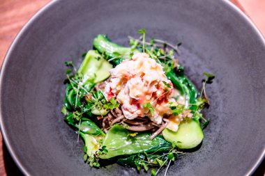 Yeşil salata yengeçler ve avokado bir plaka üzerinde olduğunu