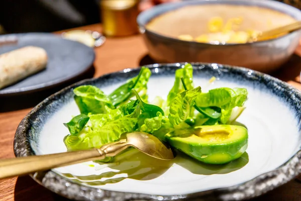 Зеленый салат с авокадо и салатом на тарелке — стоковое фото