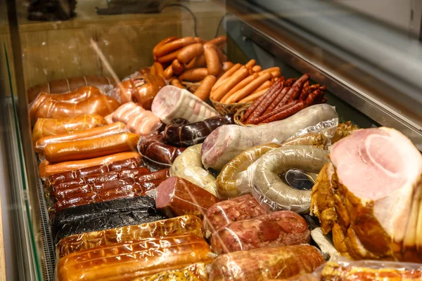 Diverse salsicce e carne pronta sul bancone del mercato . — Foto Stock