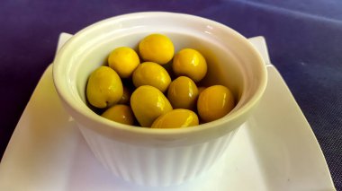 Yeşil zeytin beyaz bir kupayalan.