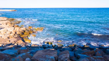 Denizin kayalık kıyısı, akşam gün batımı