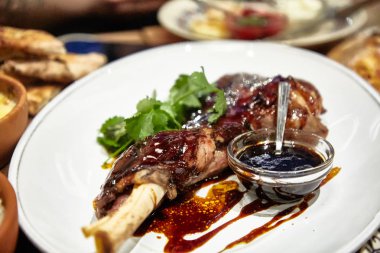 Haşlanmış bacak tavşan veya ördek soslu bir tabak üzerinde.