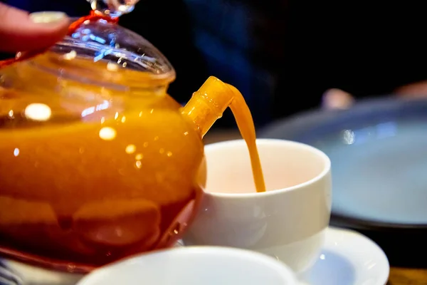 Rött te med havtorn i en tekanna i glas. — Stockfoto