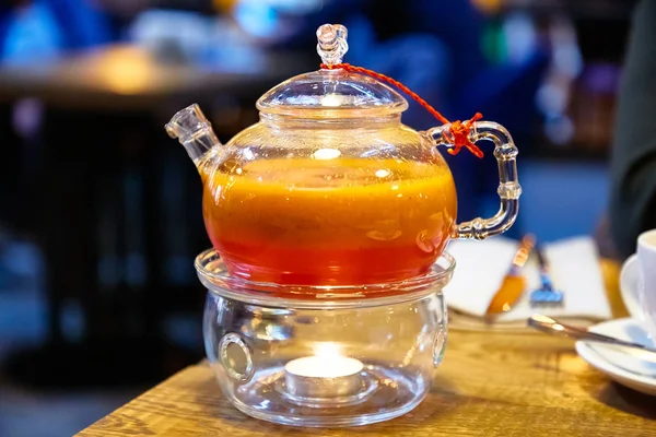 Chá vermelho com espinheiro do mar em um bule de chá de vidro . — Fotografia de Stock
