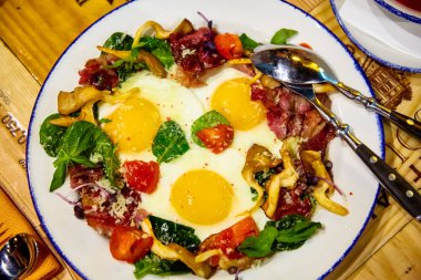 Domates, pastırma ve yeşillik ile üç yumurta kızarmış yumurta