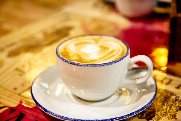 Filiżanka kawy cappuccino znajduje się na stole — Zdjęcie stockowe