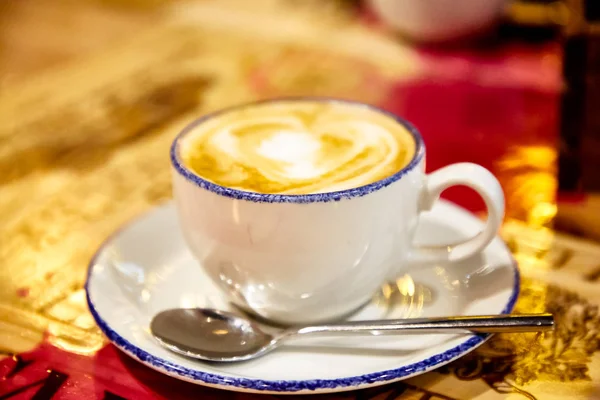 Una taza de café capuchino está sobre la mesa —  Fotos de Stock