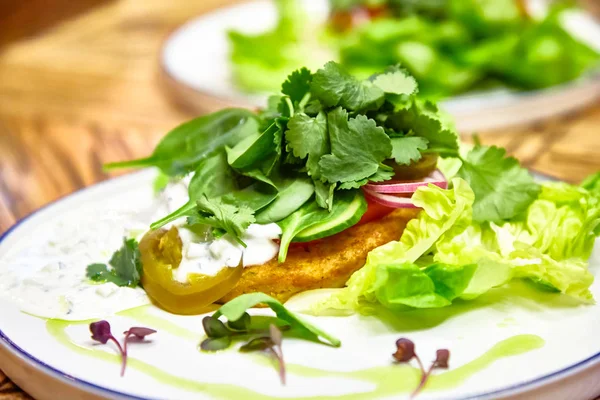 Pescado frito con perejil, lechuga, pepinos y salsa tártara — Foto de Stock