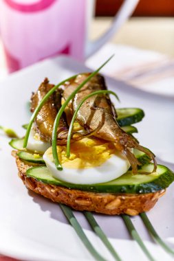 Sandviç, salatalık ve yumurta tabakta.