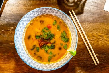 Geleneksel Asya çorbası Tom Yam masada bir tabakta