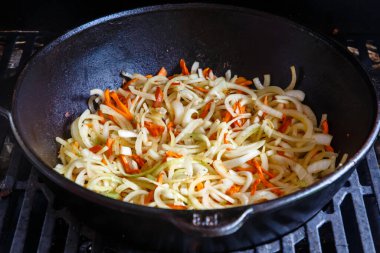 Soğan ve havuç pilav pişirmek için büyük bir tencerede kızartılır.