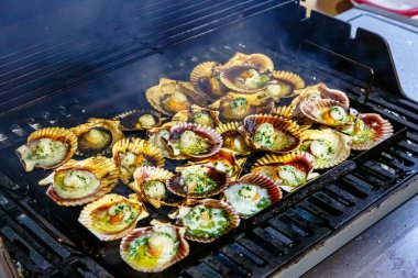 Kabuklu deniz tarakları ve baharatlar kızartılır.