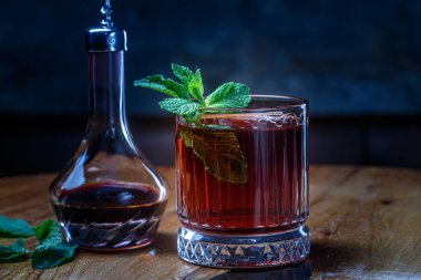 Koyu kırmızı tentür ya da bardaktaki likör gece barında masanın üzerinde.