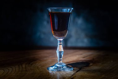 Koyu kırmızı tentür ya da bardaktaki likör gece barında masanın üzerinde.