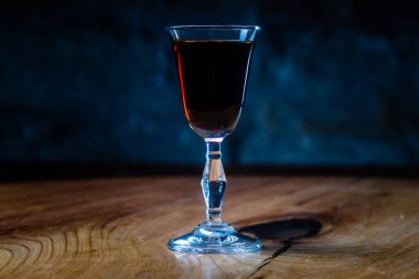 Koyu kırmızı tentür ya da bardaktaki likör gece barında masanın üzerinde.