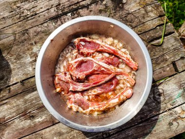 Yaz pikniğinde ızgara yapmak için soğan ve baharatla marine edilmiş kuzu filetosu.