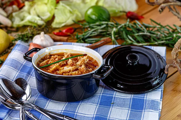 Bean and tomato puree soup with fried chicken breast is poured into a plate.