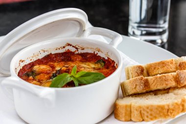 Domates soslu sebze güveci beyaz bir tencerede.