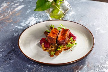 Tabakta mantarlı ızgara biftek, patates püresi ve pancar sosu var.