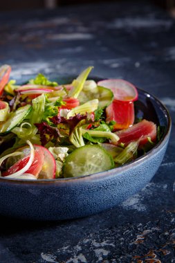 Salata salatası, kızarmış ton balığı, salatalık ve turp tabakta.