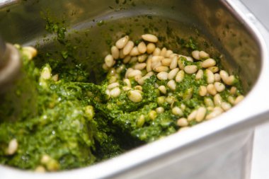 Pesto sosu tarifi. Fesleğene çam fıstığı eklenir ve çırpılmış olarak karıştırılır..