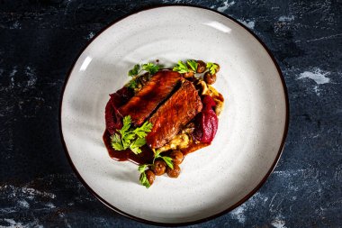 Tabakta mantarlı ızgara biftek, patates püresi ve pancar sosu var.