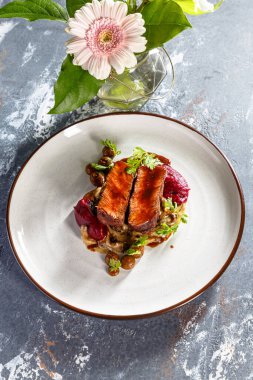 Tabakta mantarlı ızgara biftek, patates püresi ve pancar sosu var.