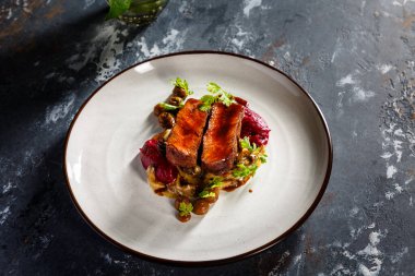 Tabakta mantarlı ızgara biftek, patates püresi ve pancar sosu var.