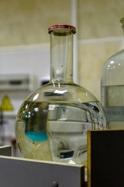 Laboratuvarda temiz bir sıvıyla dolu yuvarlak bir şişe var.