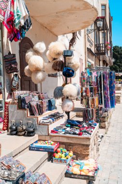 Azerbaycan 'ın Bakü şehrindeki Icherisheher' de geleneksel hediyelik eşya dükkanı. Renkli halılar, tablolar ve sokakta sergilenen diğer el yapımı eşyalar..