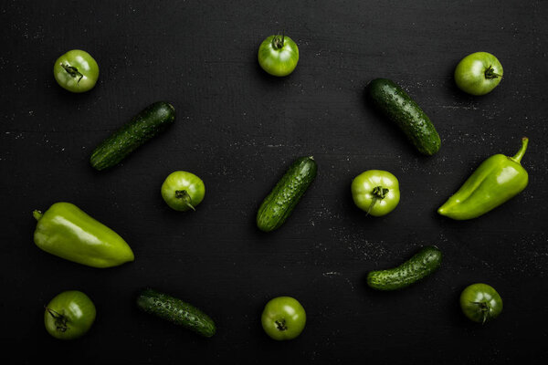 Green vegetables on dark background as a healthy eating concept of fresh garden,  symbol of health as pepper, cucumber and tomatoes