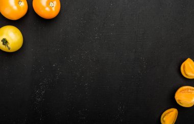 Farklı sulu domates ve siyah arka plan üzerine dilimler. Taze sebze tüketimi, en iyi görünüm için