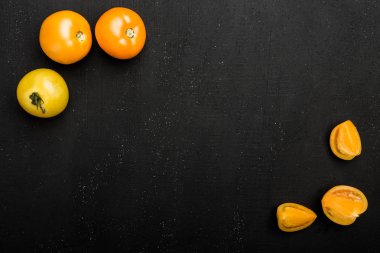 Satırı sarı domates, koyu arka plan boşluk yazmak için. Sonbahar sebze, üstten görünüm