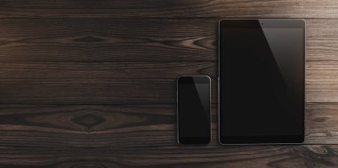 Yüksek kaliteli grafik kolaj ayrıntılı. Boş dijital tablet ve telefon üzerinde ahşap bir masa. Üstten görünüm, kopya alanı