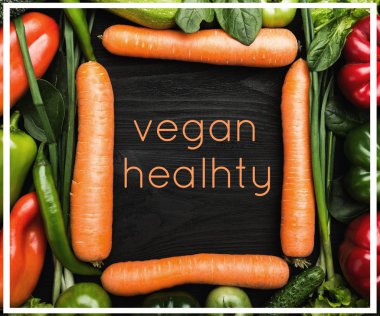 Vegan sağlıklı kavramı. Çerçeve şekli, üstten görünüm ve düz halinde düzenlenmiş sebze ürün yelpazesine yatıyordu