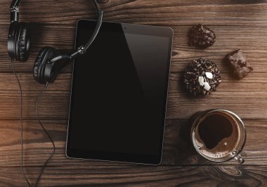 Resepsiyon tablosu konseptiyle kulaklık, tablet, bisküvi ve kahve çalışma. Kopya alanı düz yatıyordu, en iyi manzaralı