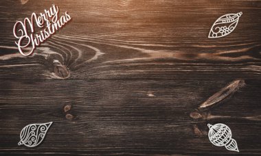 Yukarıdan görünümünü bir Merry Christmas yazıt ve el yapımı ağaç oyuncak ahşap arka plan üzerinde tebrik kartı, ampuller ile yazma metin için yer ile