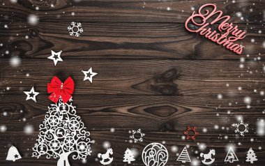 Yukarıdan bir Merry Christmas yazıt ve el yapımı ağaç oyuncak ve ahşap arka plan, metin yazma, kar efekti için yer ile tebrik kartı üzerinde kırmızı yay göster