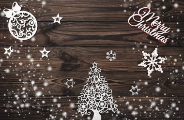 Yukarıdan bir Merry Christmas yazıt ve el yapımı Ağaç oyuncaklar ahşap arka plan, metin yazma, kar efekti için yer ile tebrik kartı üzerinde göster