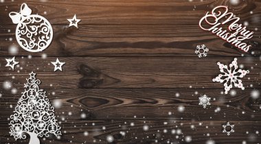 Yukarıdan görünümünü bir Merry Christmas yazıt ve el yapımı ağaç oyuncak ahşap arka plan üzerinde metin yazma, kar etkisi ve ışık boncuk yeri olan tebrik kartı