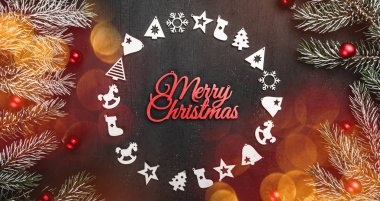 Üst, üst, görüntülemek üzerinden yukarıda, el yapımı ahşap oyuncaklar daire, yuvarlak şekli, siyah zemin üzerine yeşil dallar ve kırmızı bir Merry Christmas yazıt,